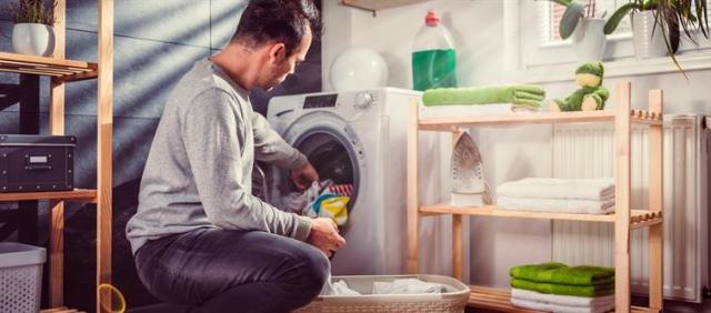 A man loads his washer dryer combo