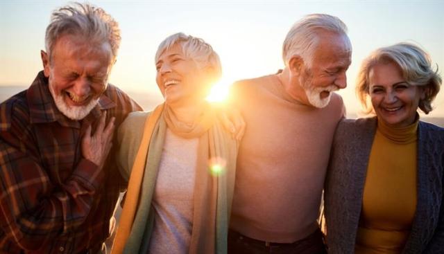 Two older couples outdoors and smiling.