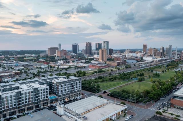 High-rise buildings tower over Birmingham, Alabama, in an aerial view of the city at sunset.