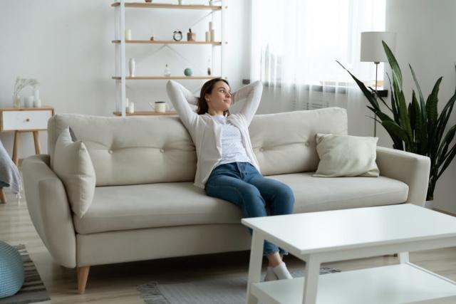 Lady sitting on sofa looking out a window