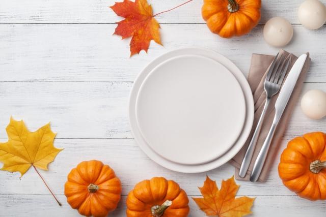A Thanksgiving dinner plate surrounded by pumpkins