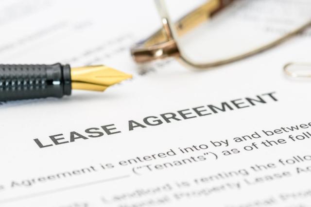 A close-up shot of a pen and pair of eyeglasses on a blank lease agreement.