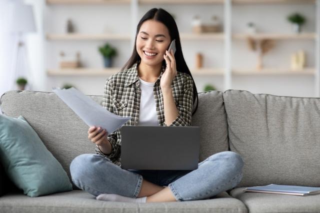 Renter sitting on her couch with her phone and laptop