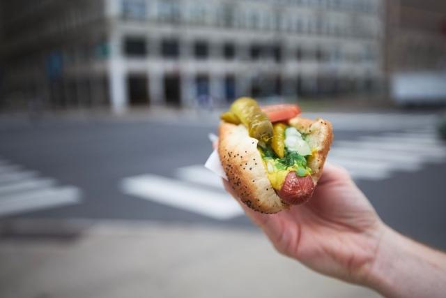 A hand holding a Chicago-style hotdog