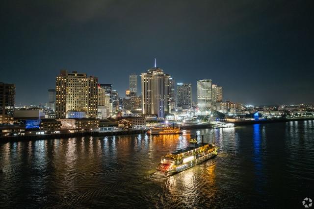Downtown New Orleans lights up the Mississippi River at night.