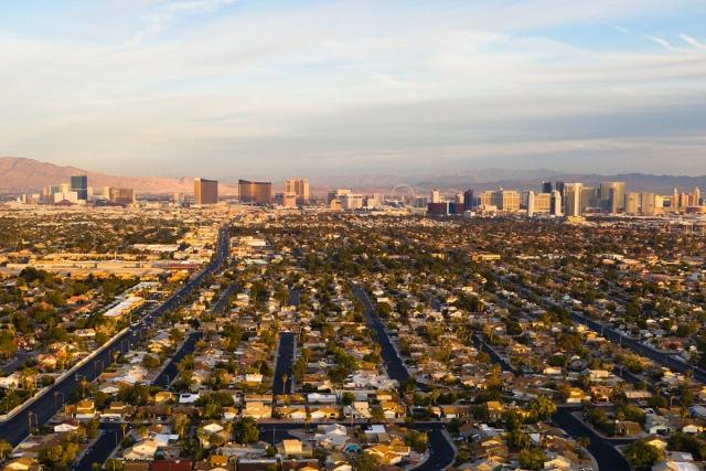 The Strip rises in the distance beyond Las Vegas suburbs.