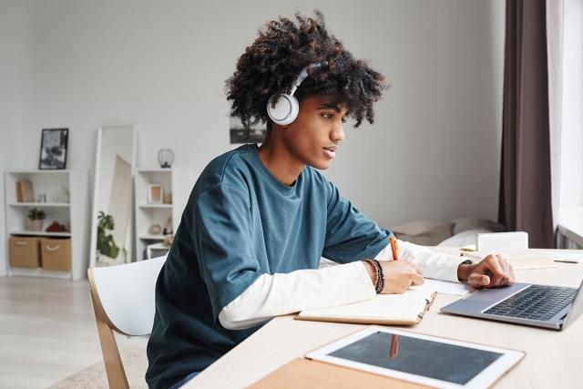 Young man studying at a desk in his apartment.