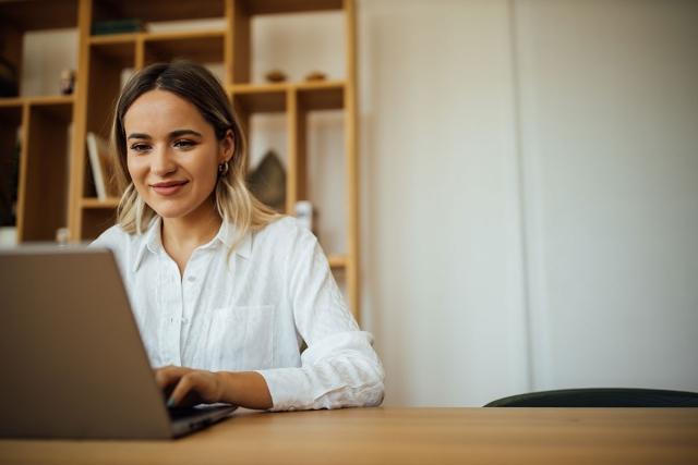 Woman searching on laptop for an apartment.
