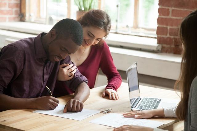 Renters signing a lease with their leasing agent.