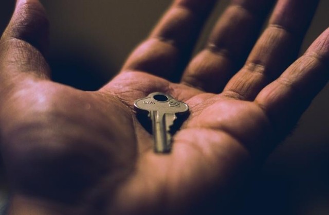 A close up of a key resting in someone's palm.