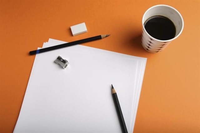A cup of coffee by a blank piece of paper