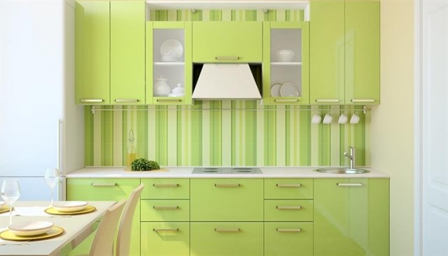 An apartment kitchen with green cabinets