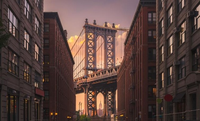 The Brooklyn Bridge framed by apartment buildings.
