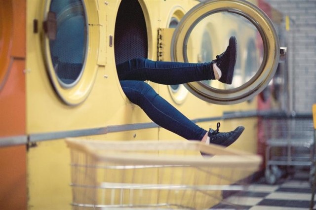 A pair of legs sticking out of a dryer