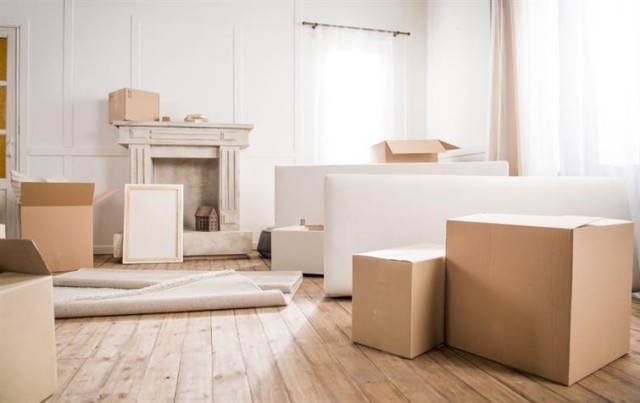 a neutral living room with moving boxes scattered around