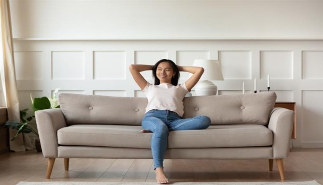A woman quietly enjoying her living room on her couch.