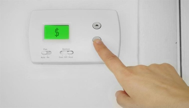 a hand manipulating the AC to save money