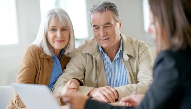 An older couple reviewing finances with an adviser.