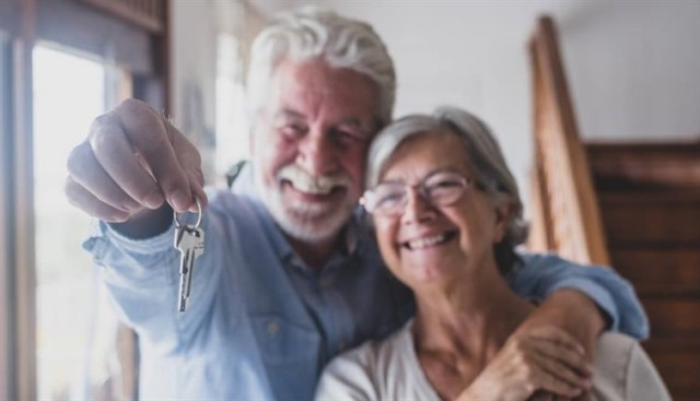 A senior couple with keys to a new home.