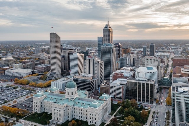 An aerial view of Downtown Indianapolis shows the city’s skyscrapers with the suburbs in the distance.