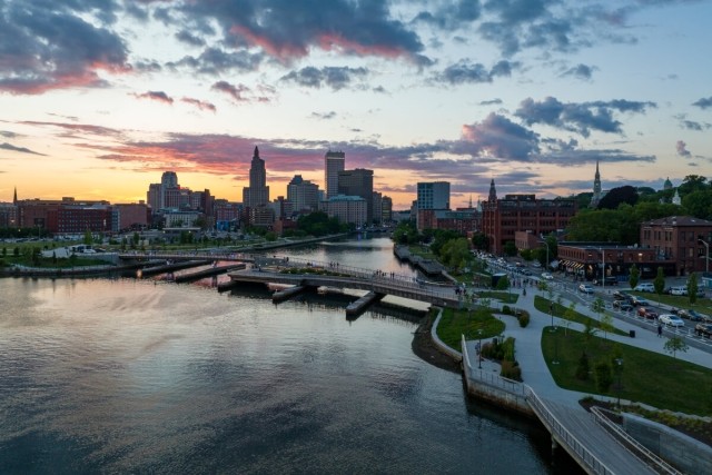 A view of Downtown Providence from the Fox Point neighborhood shows a colorful sunset behind the Providence skyline.