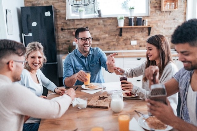 Roommates enjoying breakfast together at a cozy apartment kitchen, showcasing ideal shared living dynamics for renting with roommates.