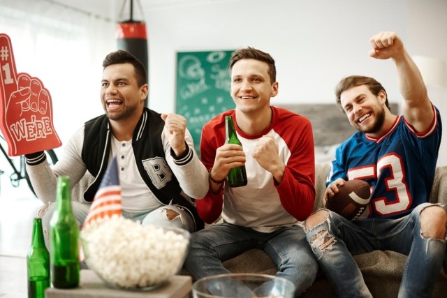 Apartment tenants watch football game in their home.