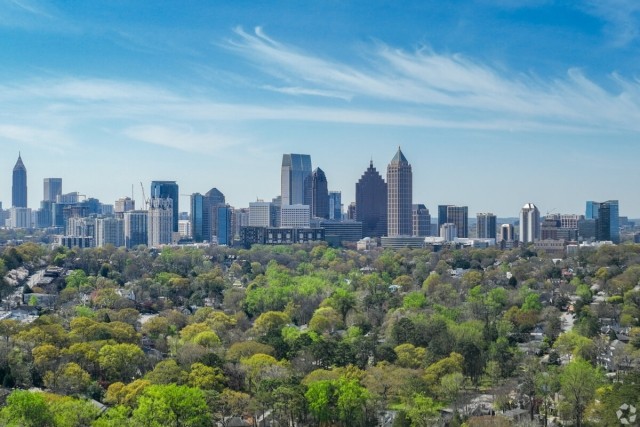 A view of the Atlanta skyline over trees.