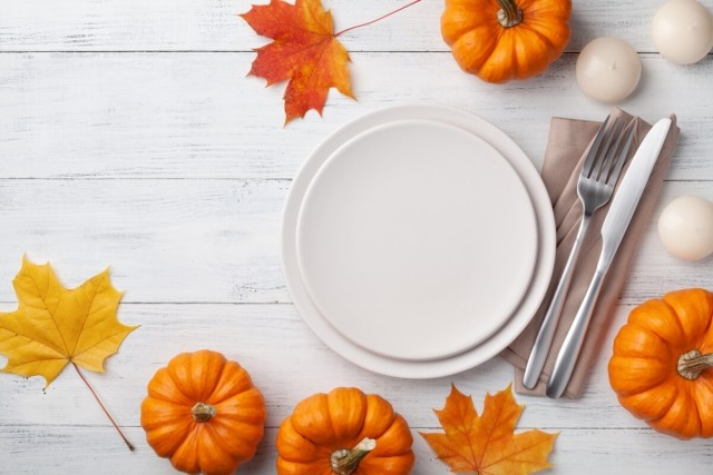 A Thanksgiving dinner plate surrounded by pumpkins
