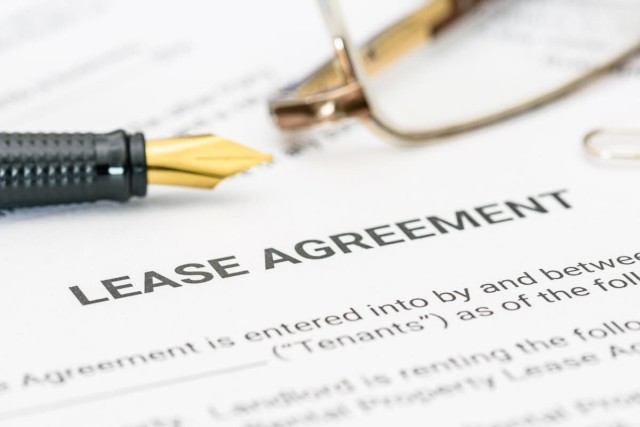 A close-up shot of a pen and pair of eyeglasses on a blank lease agreement.