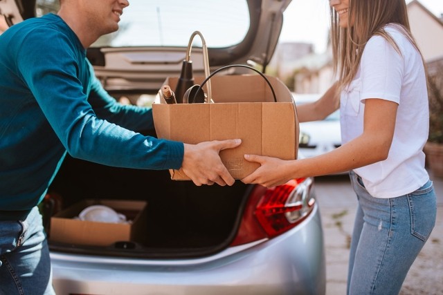 Man handing woman a box as they move out of state.