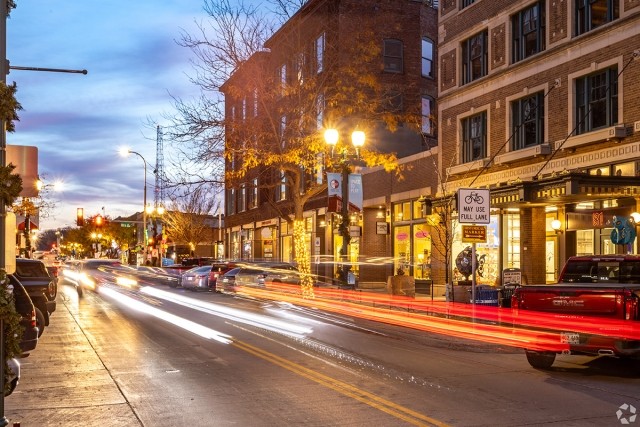 Cars drive by a small town downtown.