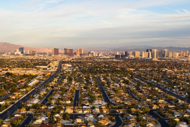The Strip rises in the distance beyond Las Vegas suburbs.