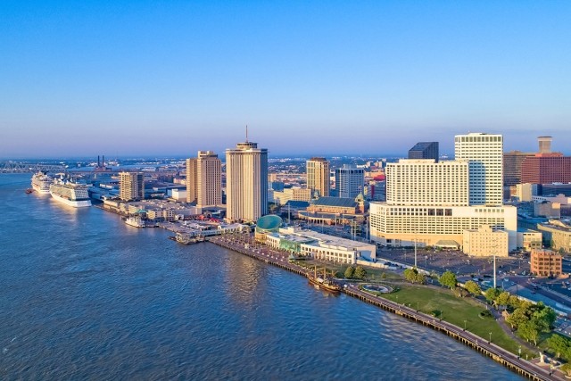 The New Orleans waterfront skyline rises above the Mississippi River.